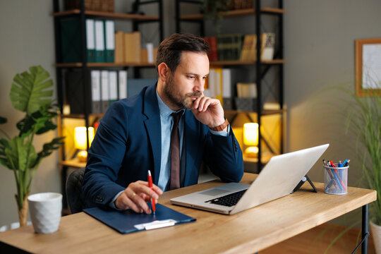 Businessman working at a laptop and taking notes