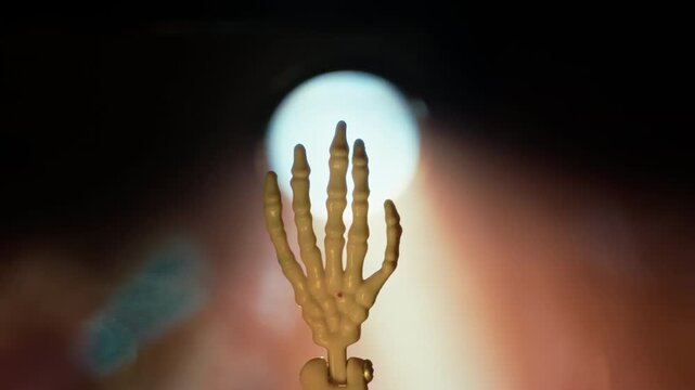 Hand of Skeleton Spooky Backlit By Glowing Light Rays And Smoke