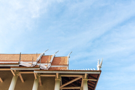 Traditional Thai temple roof architecture showcasing Asian culture and Buddhism religion against clear blue sky