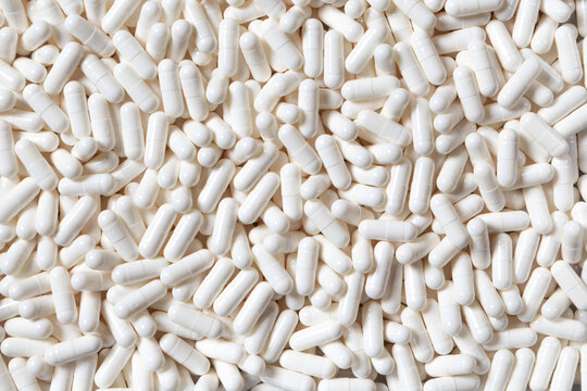 White Medicine Capsules Forming a Full Frame Pharmaceutical Background. Pills texture