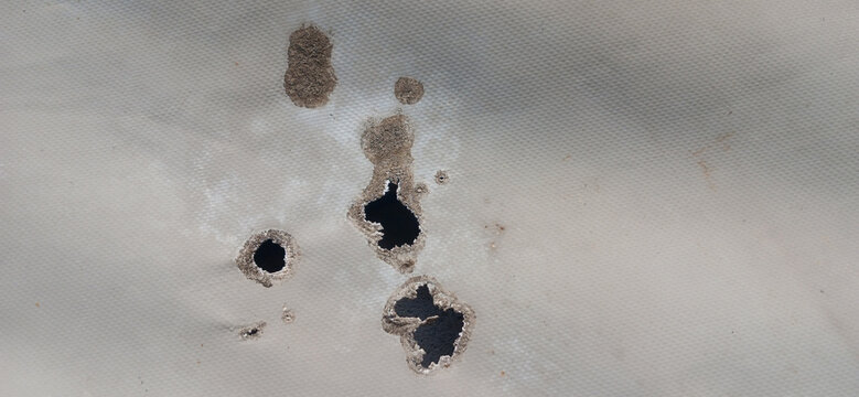 Damaged plastic sheet texture with melted burned holes