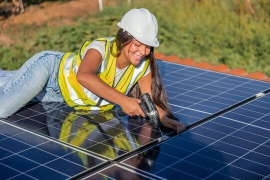 Female engineer installing solar panel for renewable energy