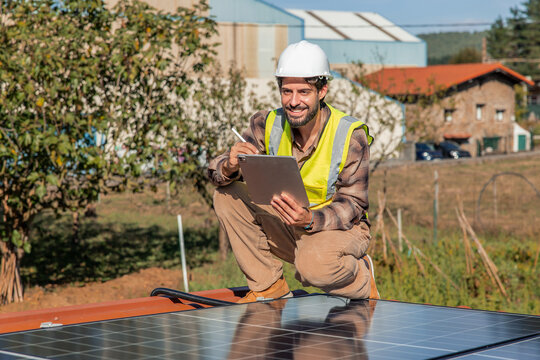 Solar engineer checking panel installation with digital tablet