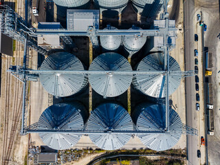 Aerial view of grain silos and industrial equipment at a storage facility during daytime © DSMT