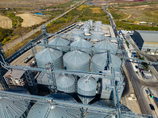 Aerial view of grain silos and conveyor systems at an agricultural storage facility during the day © DSMT