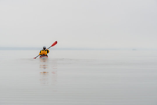 Canada, BC, Broughton Archipelago. Lone kayaker paddles towards Queen Charlotte Strait, between Vancouver Island and the mainland of BC.