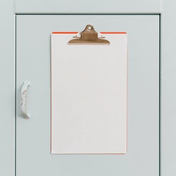 Clipboard with a blank form resting on a cool grey steel generator enclosure, featuring rain beads and copy space for inspection checklists