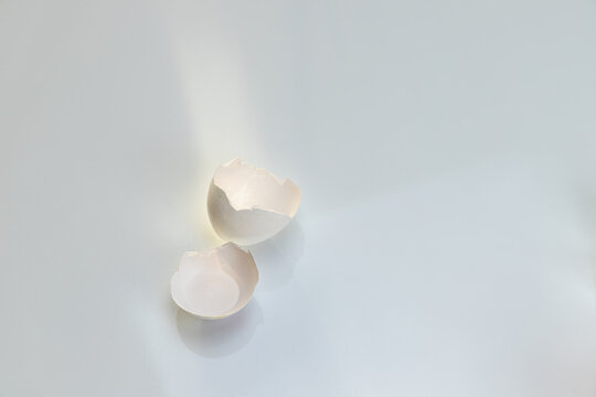 Two halves of a white eggshell on a clean white background.