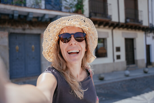 Joyful Middle Aged Expat Laughing While Taking a Selfie in Spain