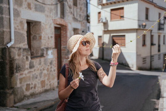 Curious Middle Aged European Expat Exploring Flowers on a Quiet Spanish Village Street