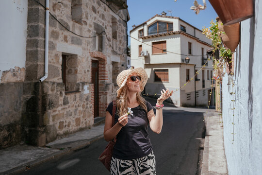 Cheerful European Expat Over 40 Admiring Flowering Vines in a Traditional Spanish Village
