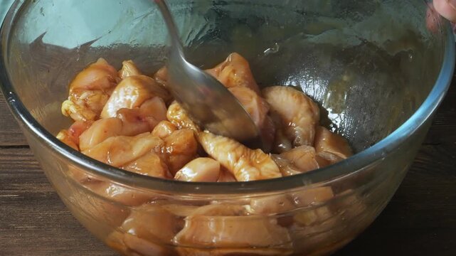 Chicken fillet marinated in teriyaki sauce with spices and garlic in a glass bowl. Close-up.