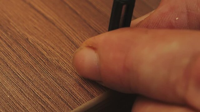 A furniture assembler screws drawer strips into place using a screwdriver. Medium shot.