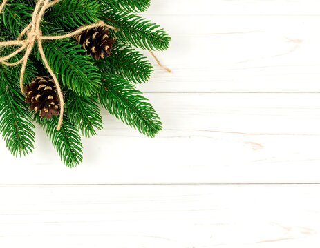 Christmas Pine Branches and Cones on White Wooden Background