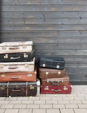 Old Travel Suitcases Against Rustic Wooden Background