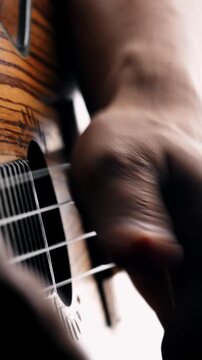 Musician strumming ukulele strings in close up view