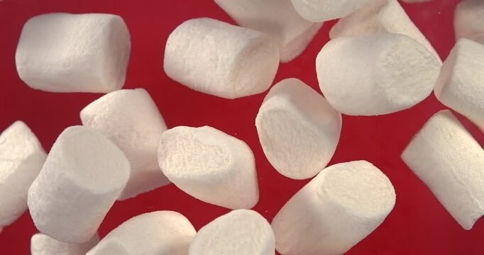 Marshmallows falling in slow motion 1000 fps on red background