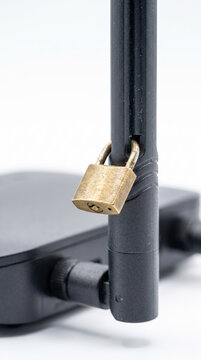 Brass Padlock Locked to Wireless Router Antenna for Network Cybersecurity Concept