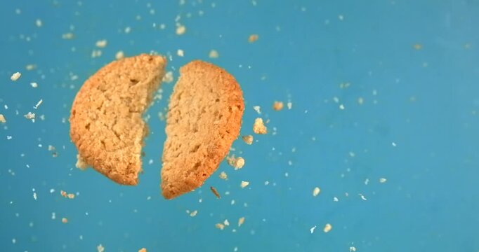 Broken butter cookie splitting in slow motion 1000 fps on blue background