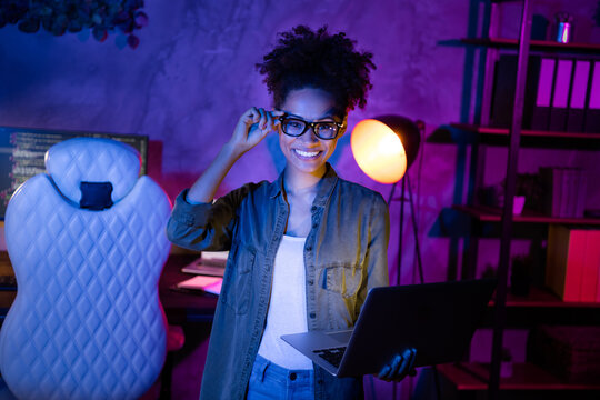 Photo of skilled lady hold netbook touch glasses ready web design java script improving in evening workplace
