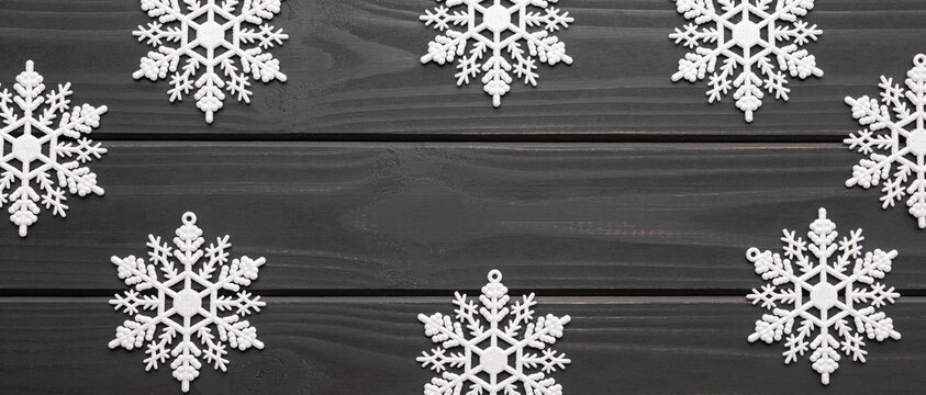 White snowflakes decoration on dark gray wooden planks background