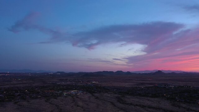 Aerial view of desert landscape and mountains at sunset with vivid sky