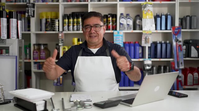 Auto parts store owner working and celebrating success at counter
