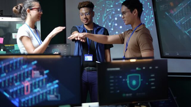 Smiling Latina woman, Black engineer and Asian colleague celebrate in front of the server screens, clapping and bumping fists, then laughing together after a successful deployment