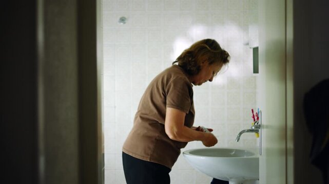 Older Caucasian woman starting her skincare routine in the bathroom