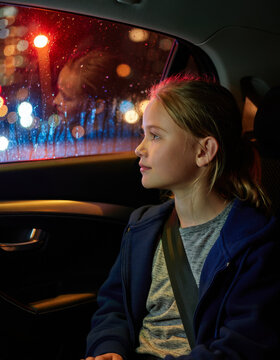 The child is sitting in the car.