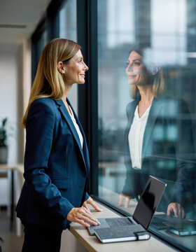 A woman and her reflection in an office window.