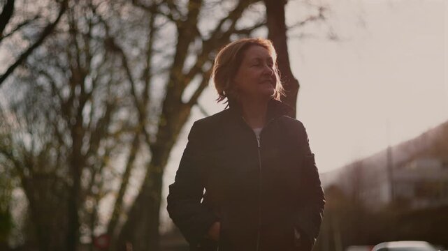 Contemplative Caucasian elderly woman outdoors at sunset