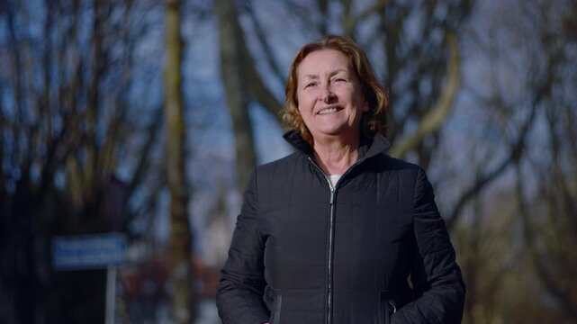 Smiling Caucasian elderly woman looking at the camera in the park