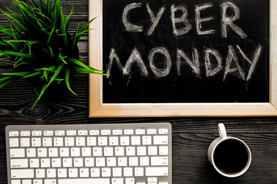 Words cyber monday written on blackboard near keyboard on grey wooden background top view