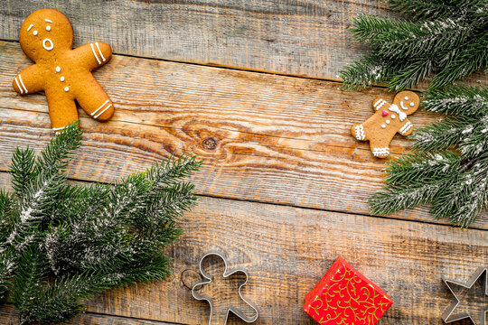 Christmas evening.Gingerbread cookies anf gift near spruce branch on rustic wooden background top view copyspace