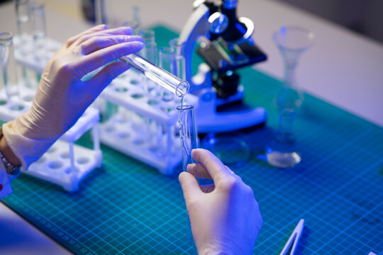 Close Up of Scientist Transferring Liquid Sample Between Test Tubes