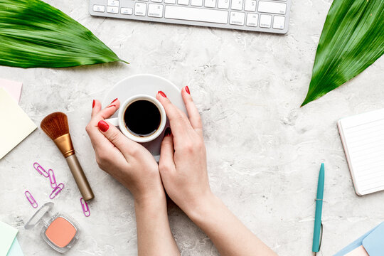 female work space with flowers, coffee, cosmetics and notebook stone background top view mockup