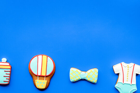 treat for baby birthday party with gingerbread cookies on blue bright background top view mock-up