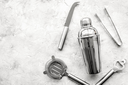 Bar tools for making cocktails on grey stone background top view copyspace