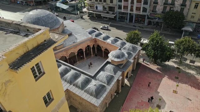 Smooth 60fps aerial view uncovering the Ottoman Alkazar courtyard and city traffic