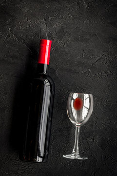 Drink red wine. Bottle and glass on black background top view copyspace