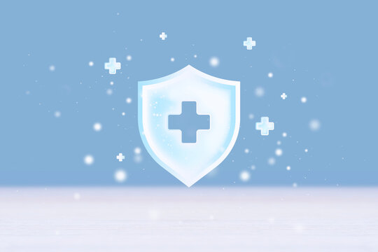 Medical cross shield icon with floating plus symbols on blue background and copy space. Health insurance, medical protection or healthcare safety concept.