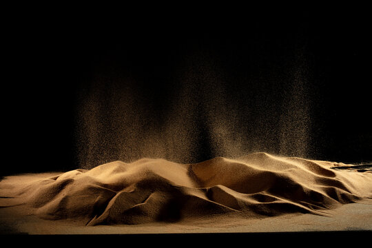 Abstract golden sand dune with glowing powder explosion splatter effects creating futuristic textured particle composition. Dramatic earth sand forms resemble wave shade splash, Photograph