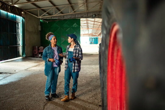 Two women discussing work in tractor shed