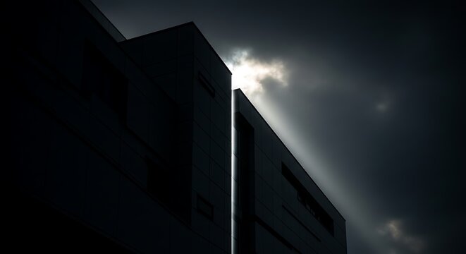 Dramatic modern building architecture against dark cloudy sky.