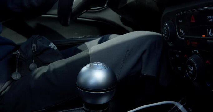 Close-up of Car Interior with Gear Shift Knob: An intimate view of a car's interior, focusing on the driver's hand resting on the metallic gear shift knob, hinting at the journey ahead.