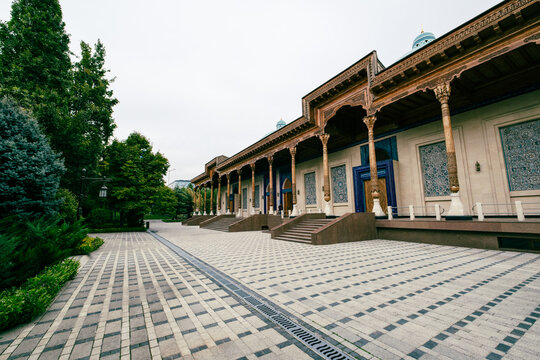 View of the Minor Mosque featuring intricate tile work, elegant wooden columns, and a paved courtyard in Tashkent, Uzbekistan.