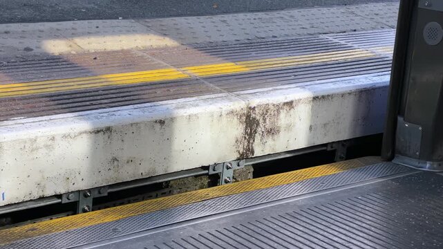 London metro subway train doors open to reveal a raised station platform, highlighting the step up and gap passengers must navigate when exiting the train. 15559  