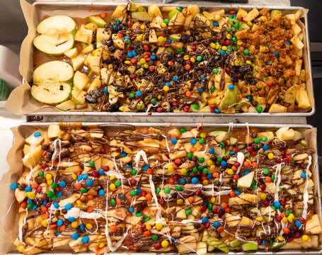 Fruit dessert tray with apple slices pineapple chunks candies chocolate drizzle glazed and crumbles!