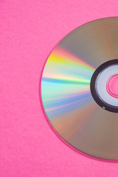 Silver compact disc on pink background